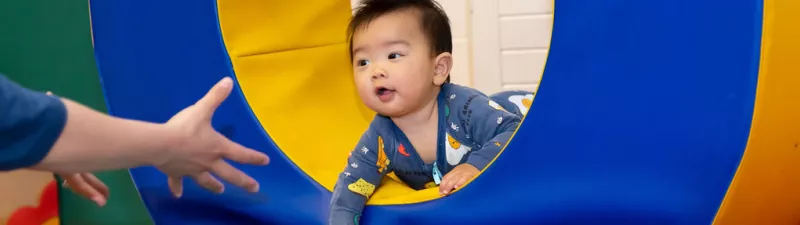 A toddler plays on the soft-play equipment