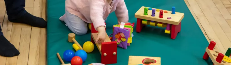 A baby plays at drop-in