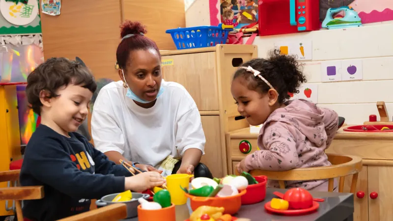 Two children and a staff member playing at Abbey's Creche