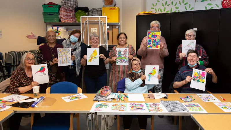 Mixed gender group showing their artwork at Colouring Calm at Abbey